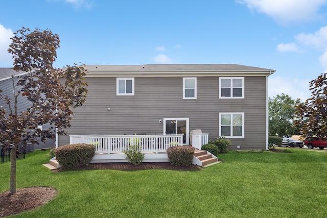 rear view of property featuring a yard and a deck