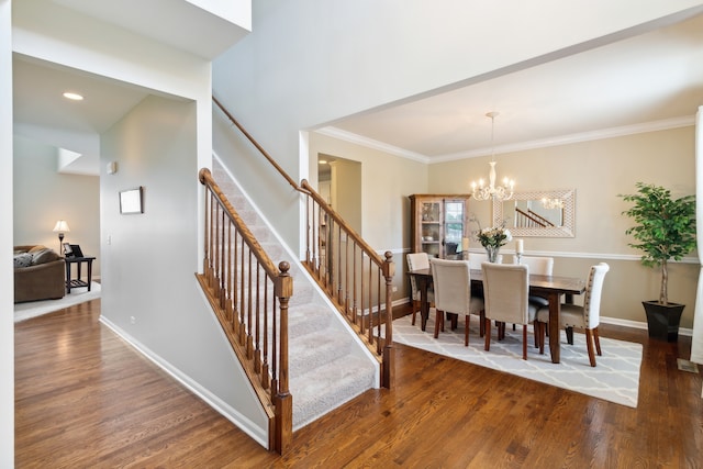 dining area featuring ornamental molding, dark wood-type flooring, and an inviting chandelier