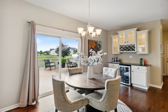 dining area featuring indoor bar, wine cooler, dark wood-type flooring, and a notable chandelier