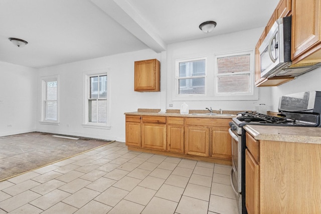 kitchen featuring beam ceiling, sink, stainless steel appliances, and light carpet