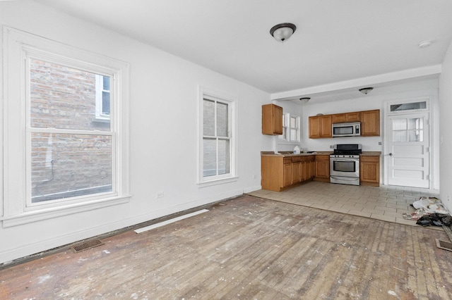 kitchen with light hardwood / wood-style floors and appliances with stainless steel finishes