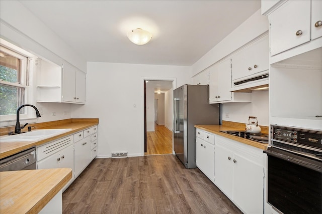 kitchen with white cabinets, dark hardwood / wood-style flooring, sink, and black appliances