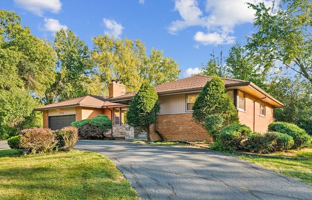 prairie-style house featuring a front lawn and a garage