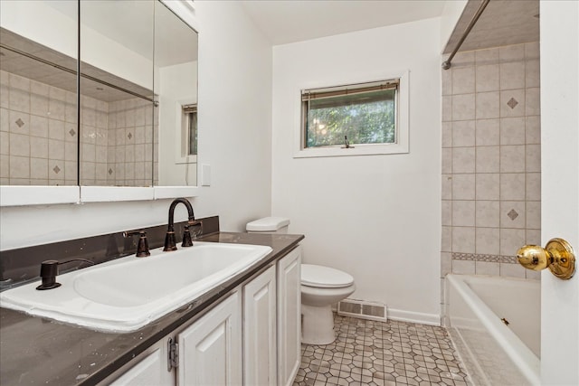 full bathroom featuring tile patterned flooring, vanity, toilet, and tiled shower / bath