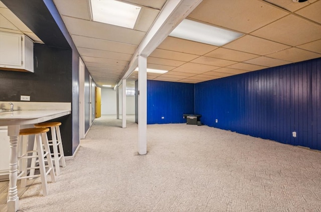 basement with light carpet and a drop ceiling