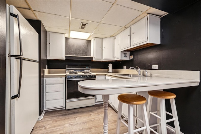 kitchen with white cabinetry, light wood-type flooring, white appliances, and sink