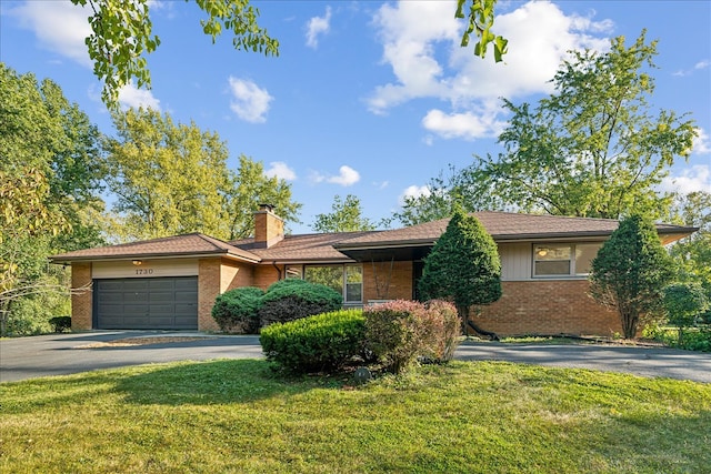 ranch-style house featuring a garage and a front lawn