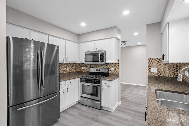 kitchen with white cabinets, light wood-type flooring, sink, and appliances with stainless steel finishes