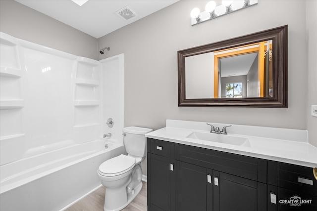 full bathroom with vanity, hardwood / wood-style floors,  shower combination, and toilet