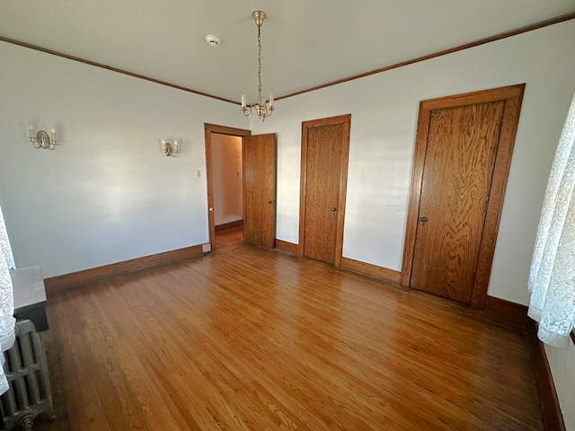 unfurnished room with wood-type flooring and an inviting chandelier