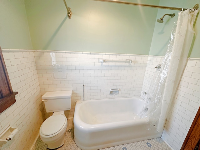 bathroom with toilet, tile patterned flooring, tile walls, and shower / tub combo with curtain