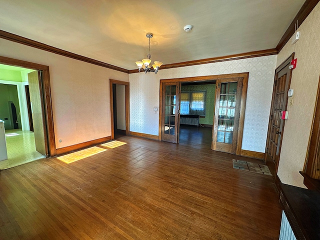 interior space with dark hardwood / wood-style flooring, ornamental molding, french doors, and a chandelier