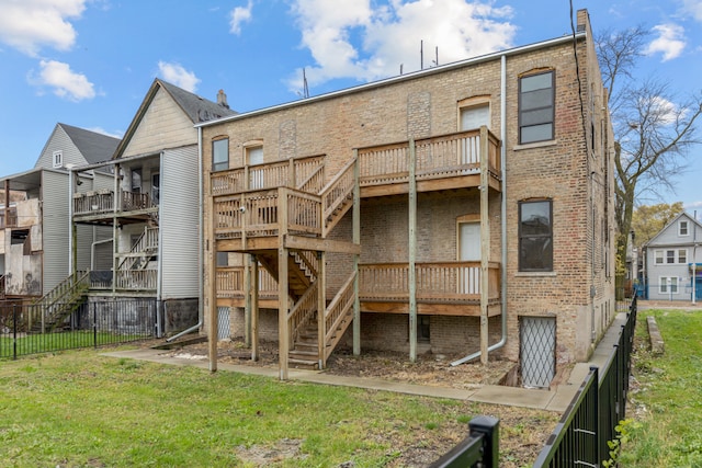 rear view of property featuring a lawn