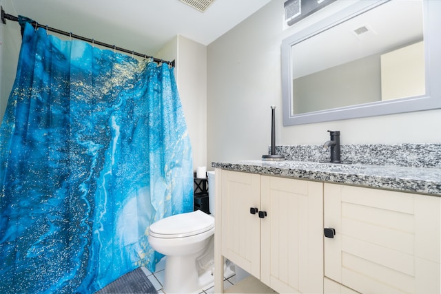 bathroom with tile patterned flooring, vanity, and toilet