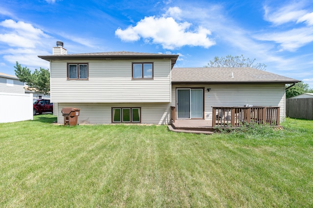 back of property with a lawn and a deck