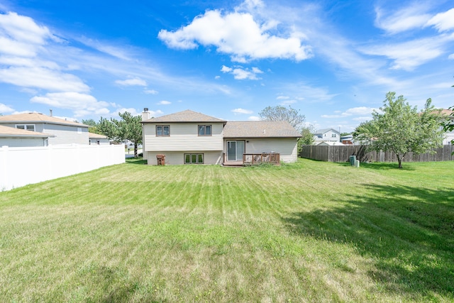 back of house featuring a lawn and a deck