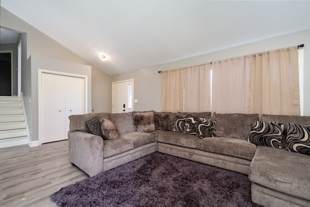 living room with light hardwood / wood-style flooring and vaulted ceiling