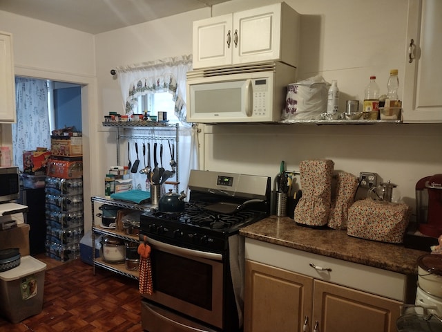 kitchen featuring dark parquet floors, stainless steel appliances, and white cabinetry