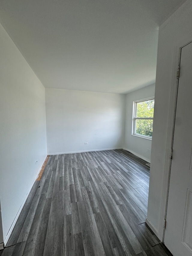 empty room with dark hardwood / wood-style flooring