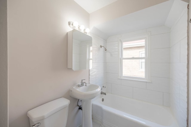 bathroom featuring tiled shower / bath and toilet