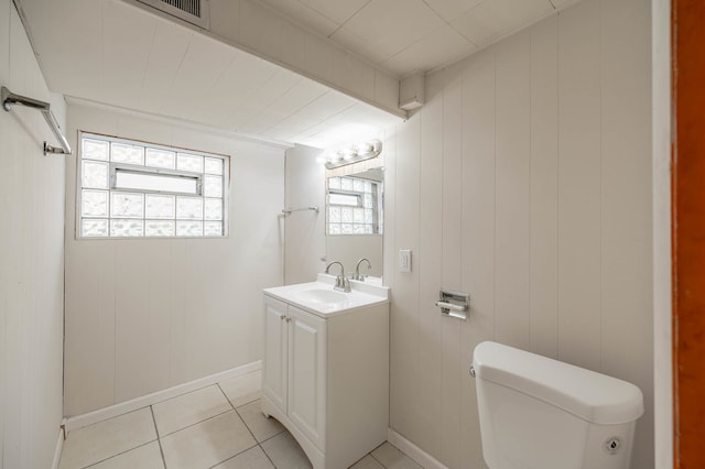 bathroom with tile patterned floors, vanity, toilet, and wooden walls