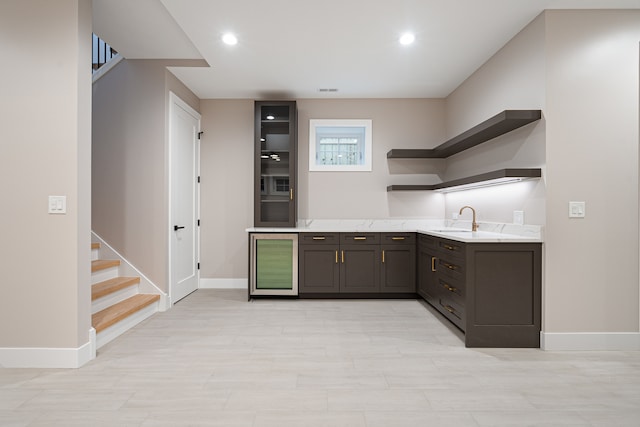 kitchen with dark brown cabinets, beverage cooler, and sink