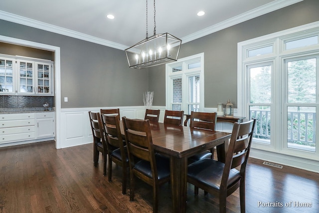 dining room featuring dark hardwood / wood-style floors, a wealth of natural light, and crown molding