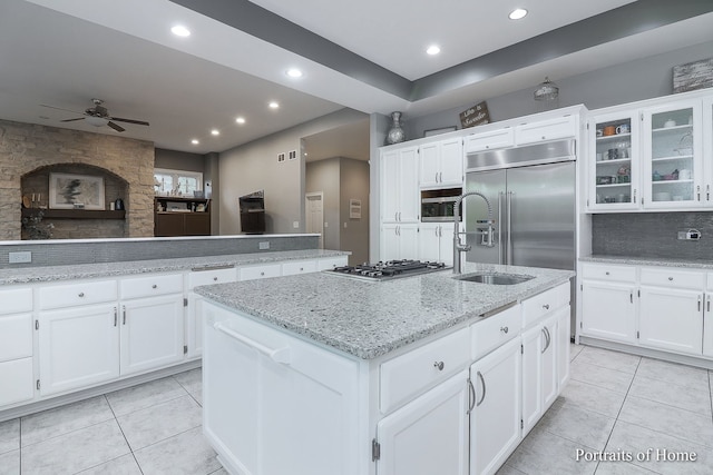 kitchen featuring white cabinets, ceiling fan, an island with sink, and appliances with stainless steel finishes