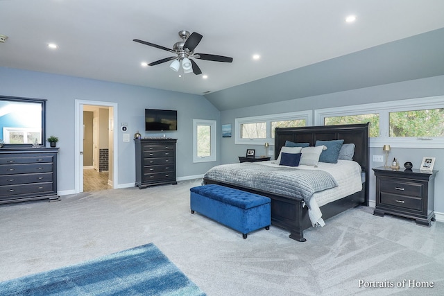 carpeted bedroom with multiple windows, ceiling fan, and vaulted ceiling