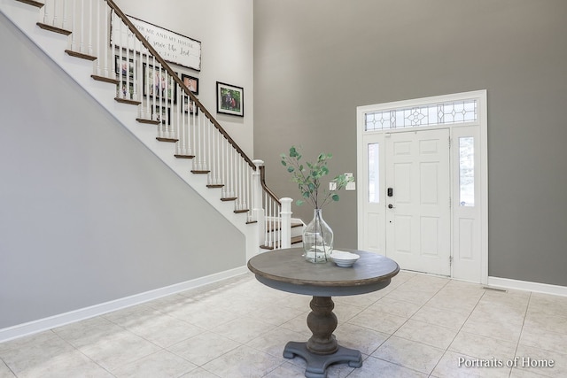 entrance foyer with light tile patterned flooring and a high ceiling