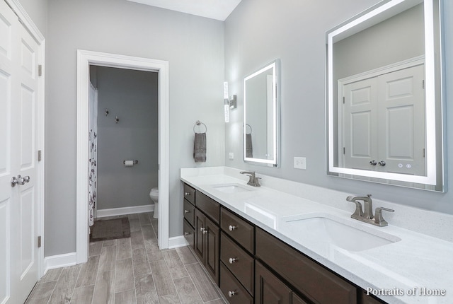 bathroom featuring hardwood / wood-style floors, vanity, and toilet