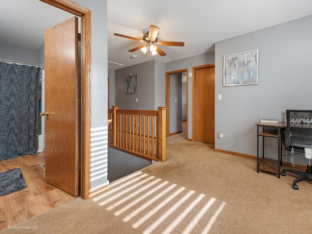 carpeted home office featuring ceiling fan