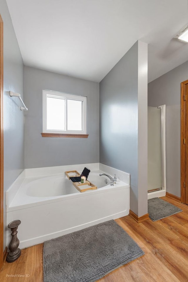 bathroom featuring hardwood / wood-style floors and plus walk in shower