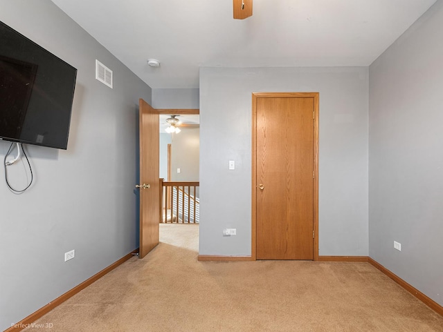 spare room featuring ceiling fan and light carpet