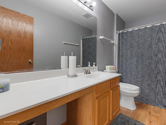 bathroom featuring vanity, hardwood / wood-style flooring, and toilet