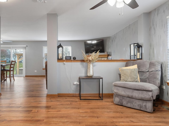 sitting room with ceiling fan and light wood-type flooring