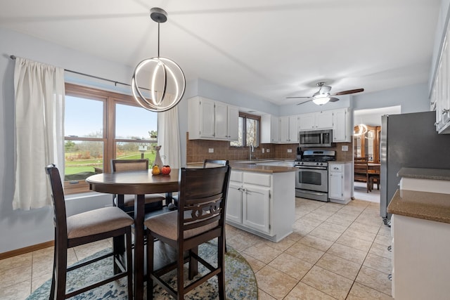 kitchen featuring sink, ceiling fan, appliances with stainless steel finishes, tasteful backsplash, and white cabinetry