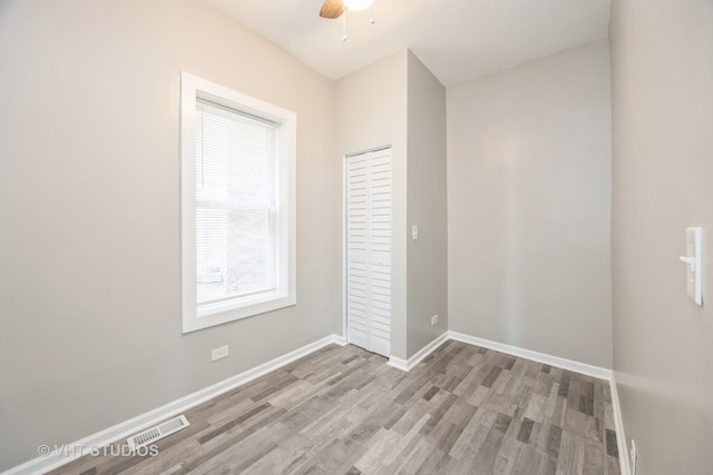 spare room with ceiling fan and light wood-type flooring