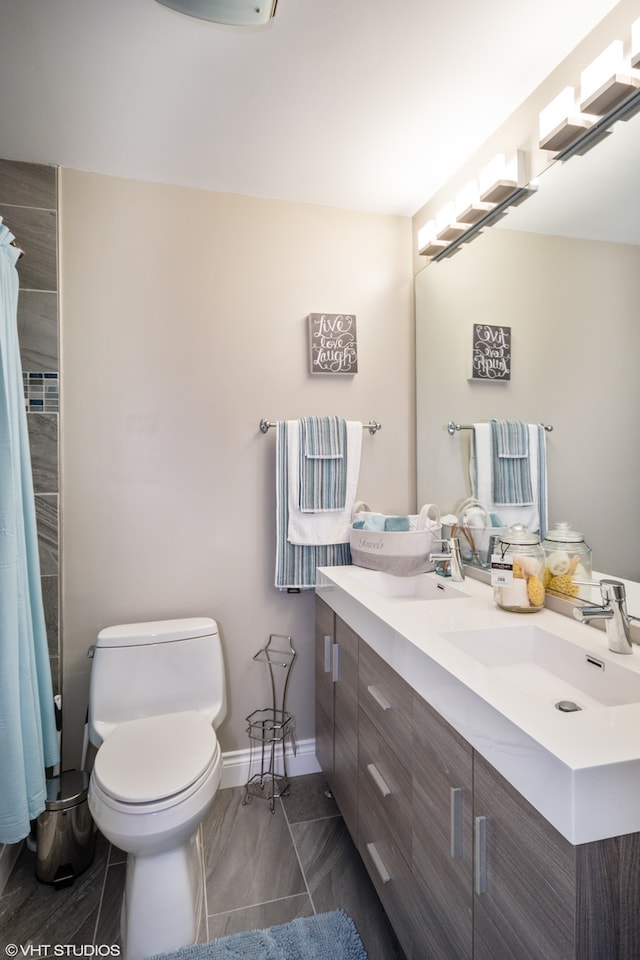 bathroom featuring tile patterned flooring, vanity, toilet, and walk in shower