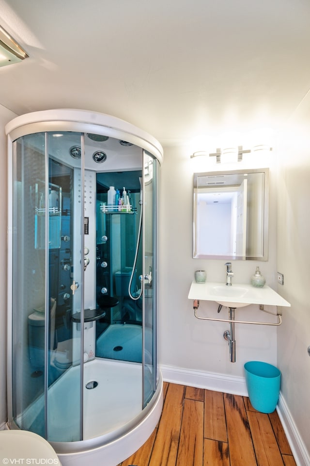 bathroom with wood-type flooring and a shower with door