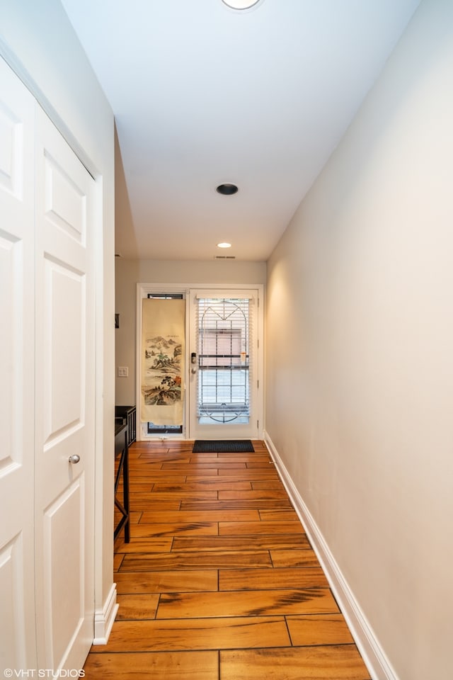 hallway with light hardwood / wood-style floors