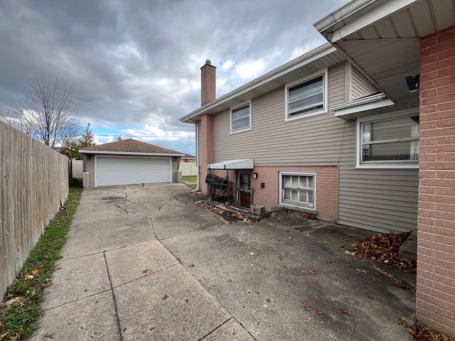 rear view of property featuring a garage and an outdoor structure