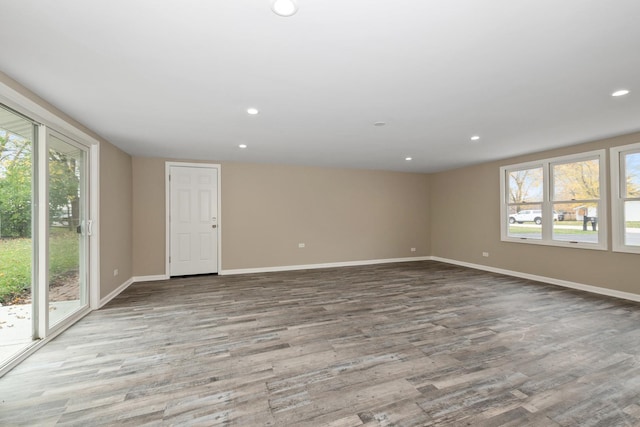 spare room featuring light hardwood / wood-style flooring and a healthy amount of sunlight