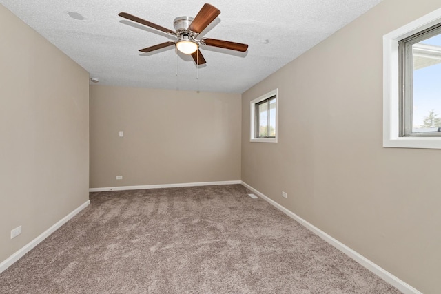 carpeted empty room with a textured ceiling and ceiling fan