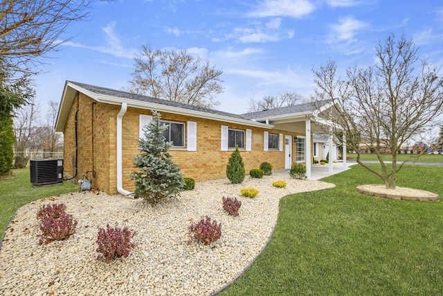 view of front of property with central AC unit, a patio, and a front lawn