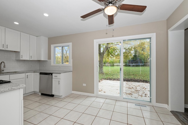 kitchen with dishwasher, sink, tasteful backsplash, light stone counters, and white cabinetry