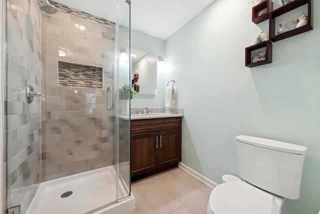 bathroom featuring vanity, a shower with shower door, tile patterned floors, and toilet