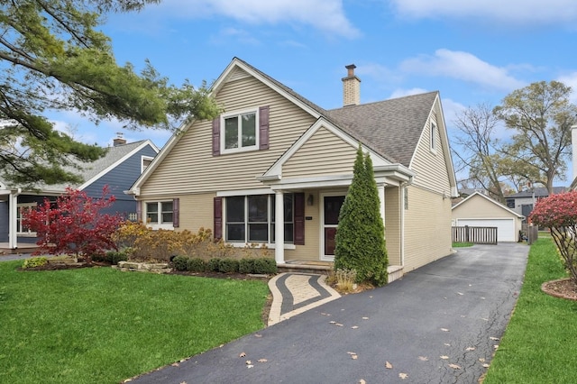 view of front of home with an outbuilding, a garage, and a front lawn