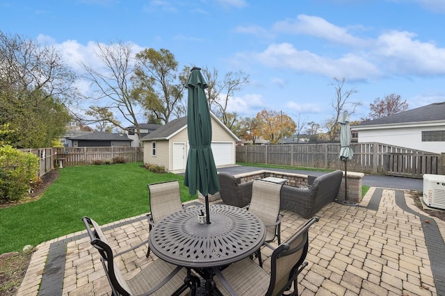 view of patio / terrace with a garage and an outbuilding