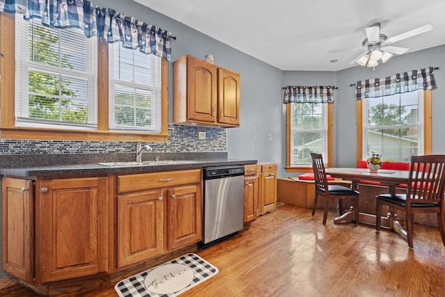 kitchen featuring ceiling fan, sink, stainless steel dishwasher, light hardwood / wood-style floors, and decorative backsplash